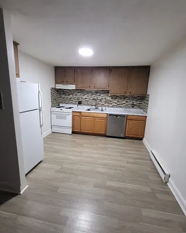 a large kitchen with kitchen island a stove a refrigerator sink and white cabinets