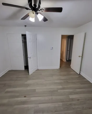 a view of an empty room with a chandelier fan