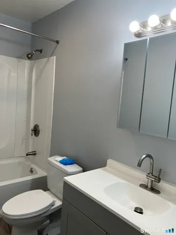 a view of empty room with wooden floor and window