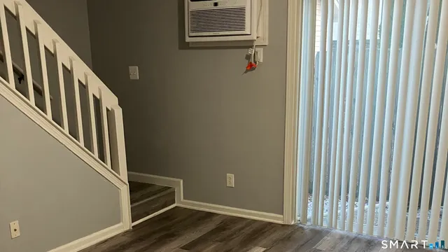 a view of a hallway with wooden floor and closet