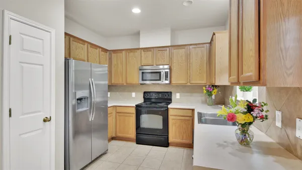 a kitchen with stainless steel appliances granite countertop a refrigerator and a stove top oven