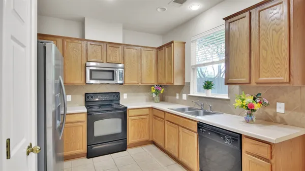 a kitchen with a sink stove top oven and refrigerator