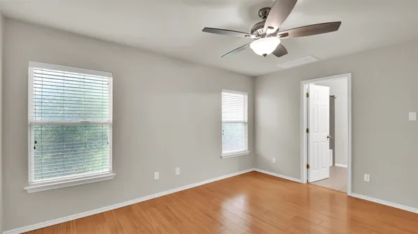 a view of an empty room with a window and wooden floor