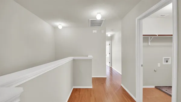a view of hallway with stairs and wooden floor