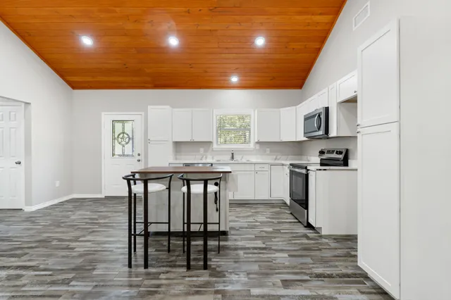 a kitchen with granite countertop a stove a sink and a refrigerator