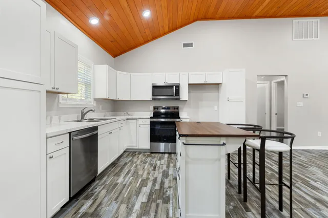 a kitchen with granite countertop a sink stove and refrigerator