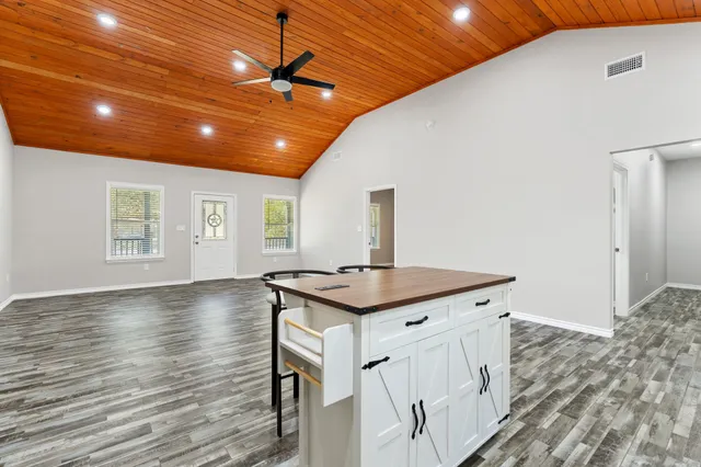 a kitchen with a stove and a wooden floor