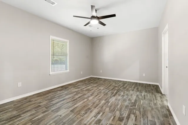 wooden floor in an empty room with a window