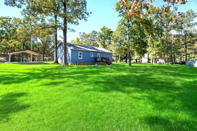 a house with a big yard and large trees