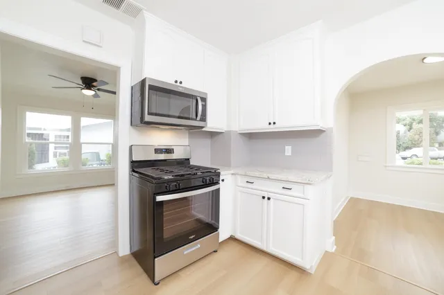 a stove top oven sitting inside of a kitchen