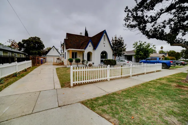 a view of a house with a small yard and sitting area