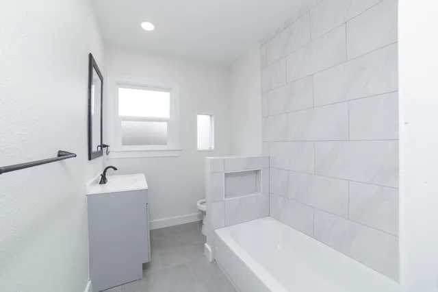 a bathroom with bathtub sink and mirror