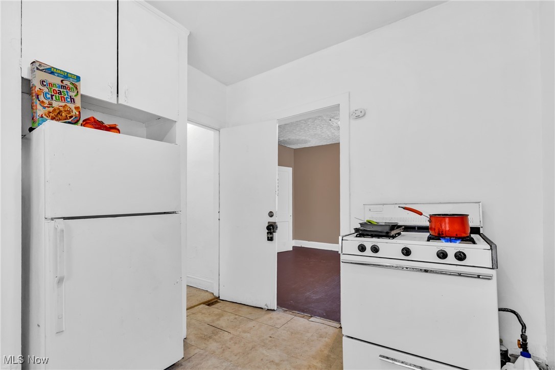 3770 Mayfield Road Cleveland Heights, OH 44121 - Photo 7 of 22 Kitchen with white cabinetry, light tile patterned floors, and white appliances