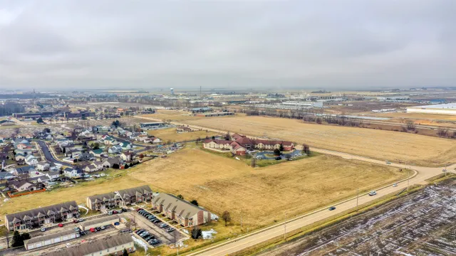 an aerial view of ocean and residential houses with outdoor space
