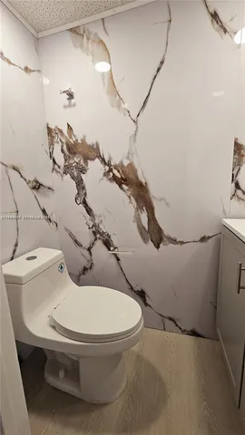 a white toilet sitting next to a bathroom sink and vanity