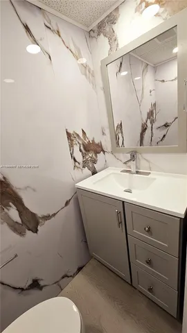 a bathroom with a sink and mirror with toilet