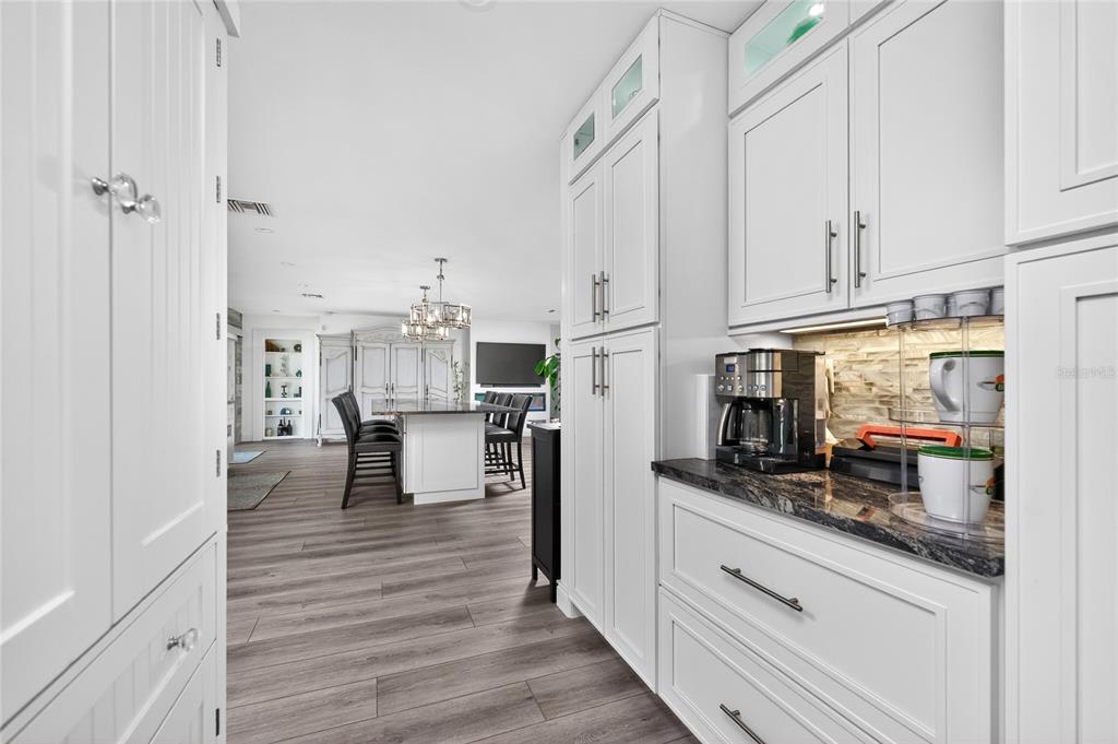 391 Vía Esplanade Punta Gorda, FL 33950 - Photo 13 of 60 a kitchen with stainless steel appliances white cabinets and wooden floor