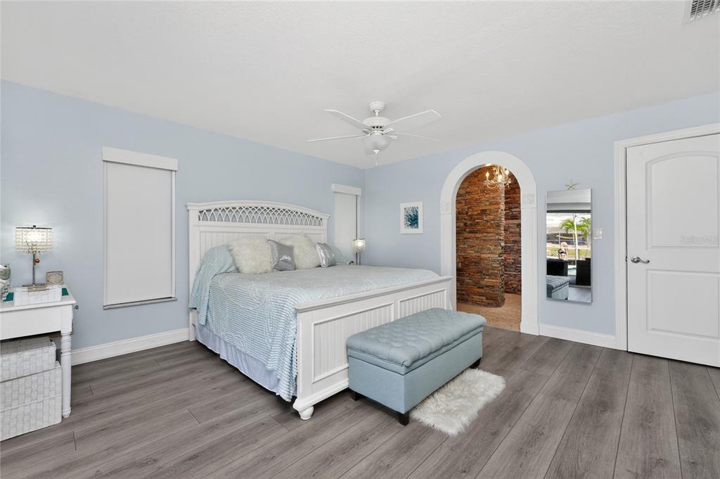 391 Vía Esplanade Punta Gorda, FL 33950 - Photo 18 of 60 a bedroom with a large bed and a chandelier