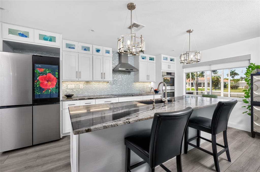 391 Vía Esplanade Punta Gorda, FL 33950 - Photo 8 of 60 a kitchen with stainless steel appliances a dining table chairs stove and cabinets