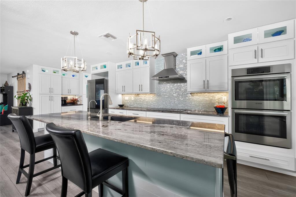 391 Vía Esplanade Punta Gorda, FL 33950 - Photo 9 of 60 a kitchen with stainless steel appliances granite countertop a stove top oven a sink and cabinets