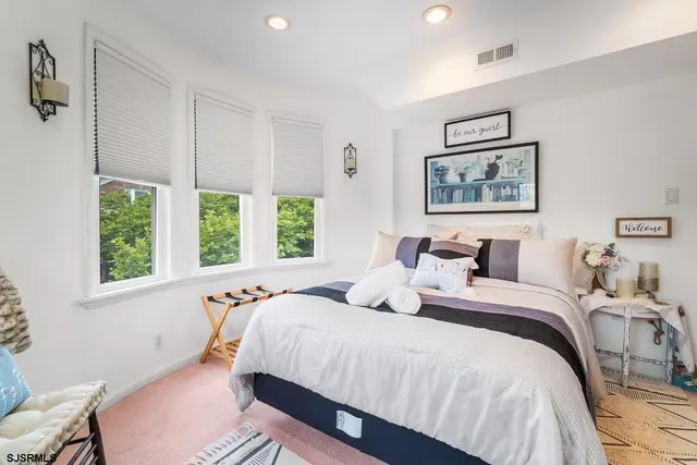 a kitchen with granite countertop lots of white furniture appliances and windows