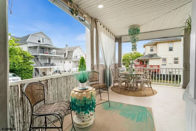 a view of a balcony with chairs and a potted plant