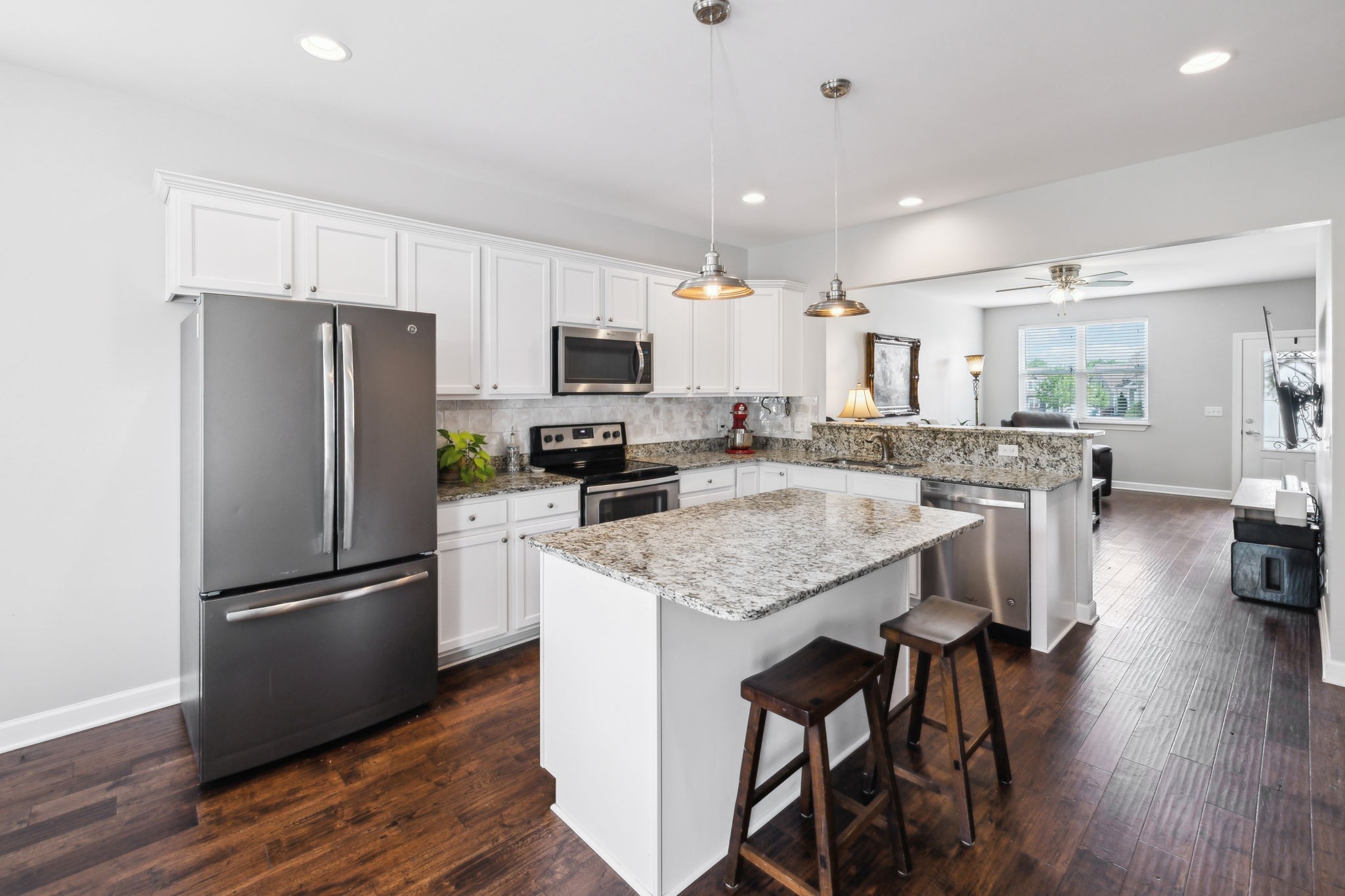 712 Ellie Drive Madison, TN 37115 - Photo 9 of 35 a kitchen with stainless steel appliances granite countertop a refrigerator a stove a sink a dining table and chairs with wooden floor