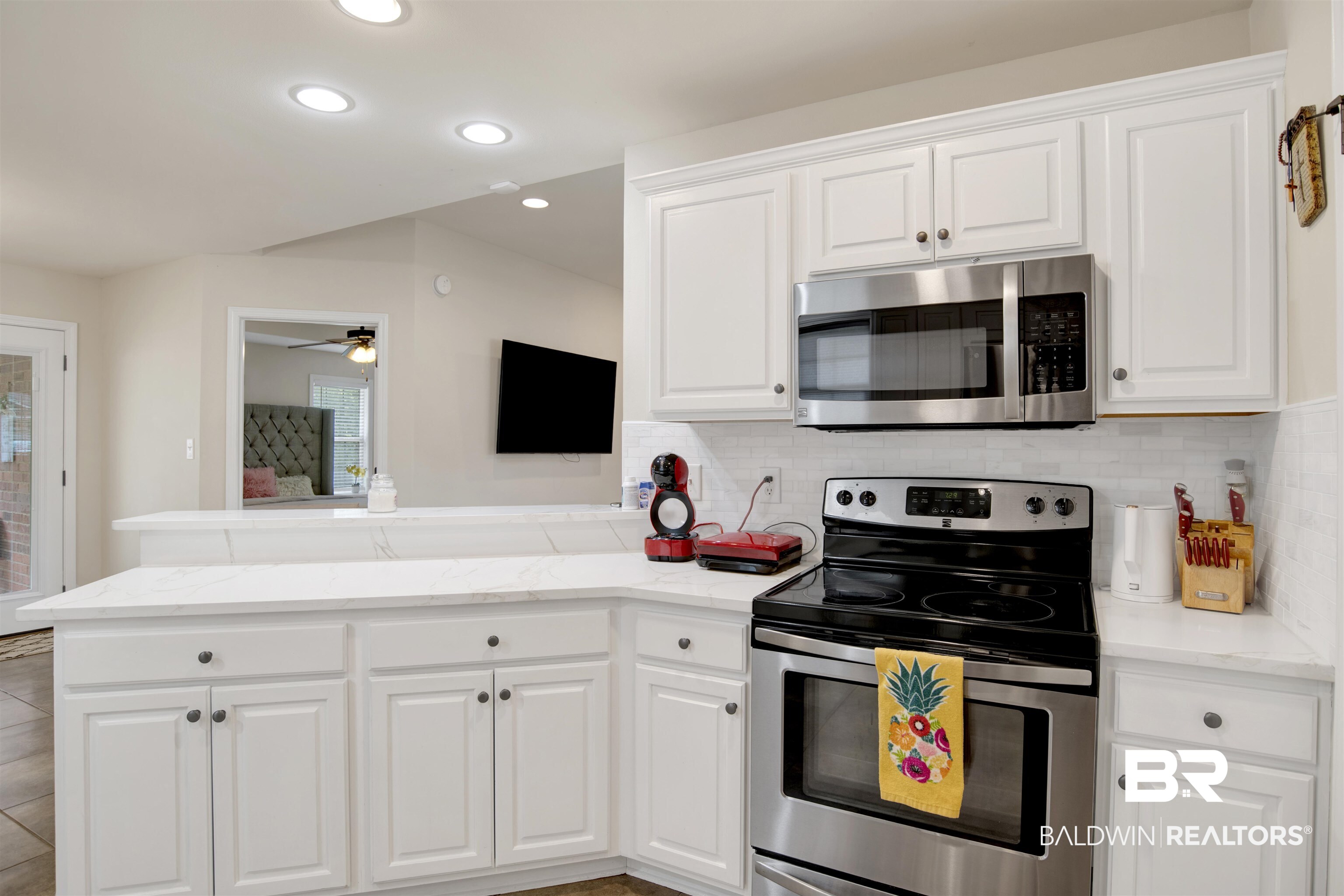 8542 Three Dean Way Mobile, AL 36695 - Photo 13 of 26 Kitchen with appliances with stainless steel finishes, a peninsula, decorative backsplash, white cabinetry, and recessed lighting