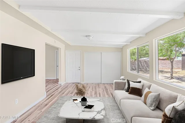 a living room with furniture a flat screen tv and a large window