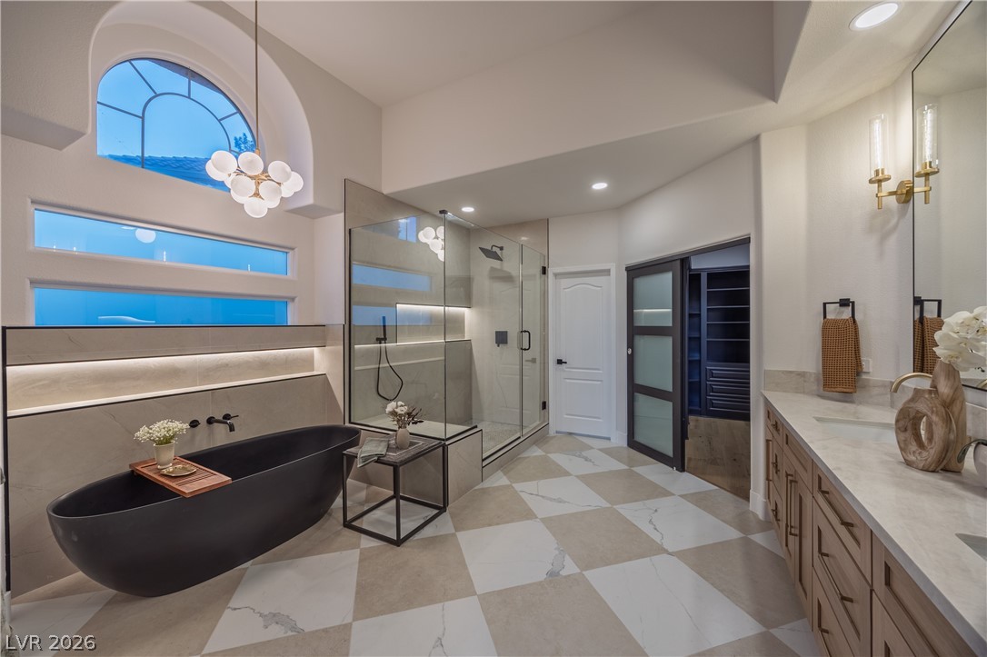 8800 Lusso Las Vegas, NV 89134 - Photo 44 of 85 Bathroom featuring a stall shower, a freestanding bath, vanity, hanging lights, and light flooring