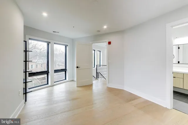a view of a brick building next to a road with large trees