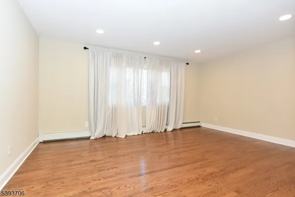 an empty room with wooden floor and window