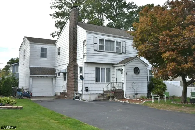 a front view of a house with a garden and trees