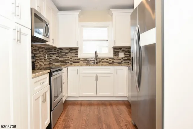 a kitchen with granite countertop white cabinets and white appliances