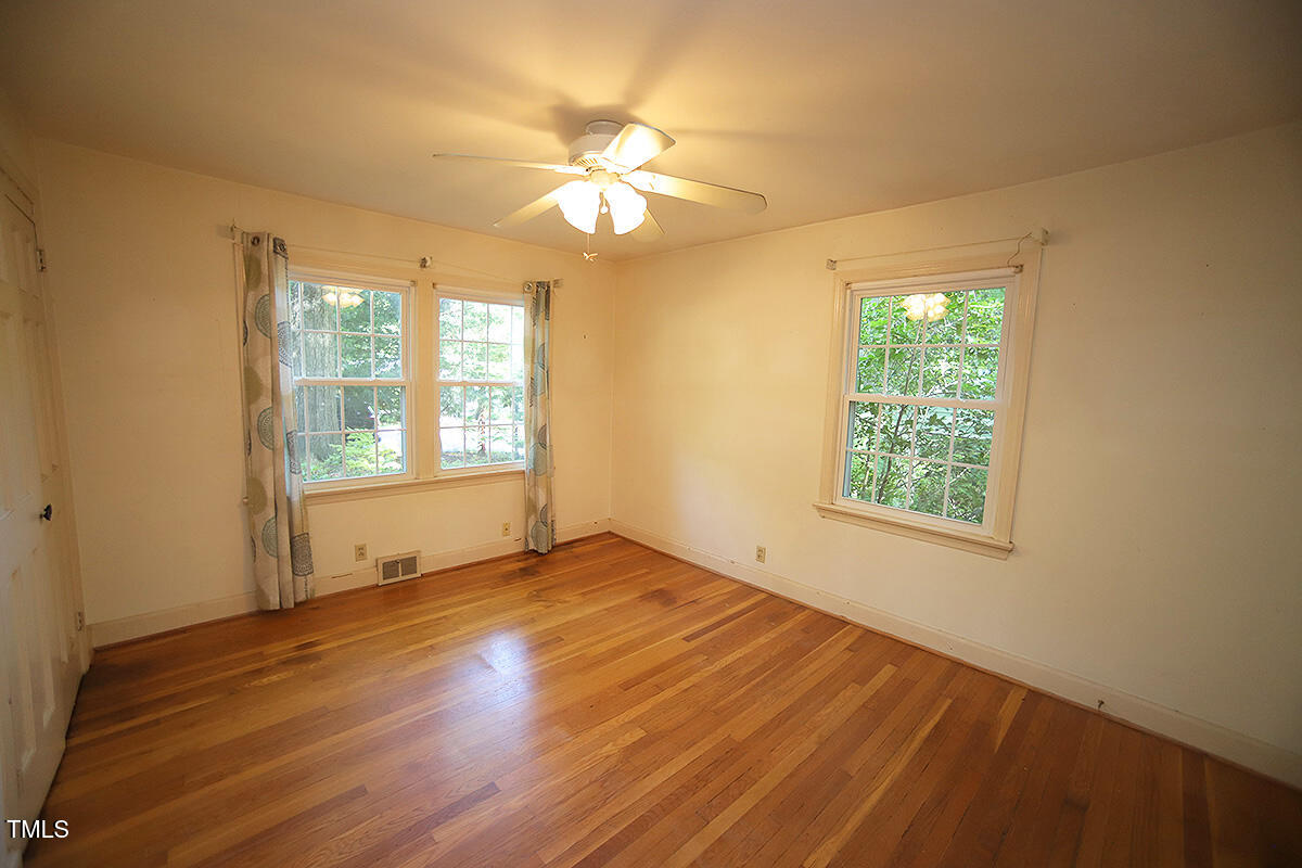 630 Stacy Street Raleigh, NC 27607 - Photo 16 of 39 a view of an empty room with wooden floor and a window