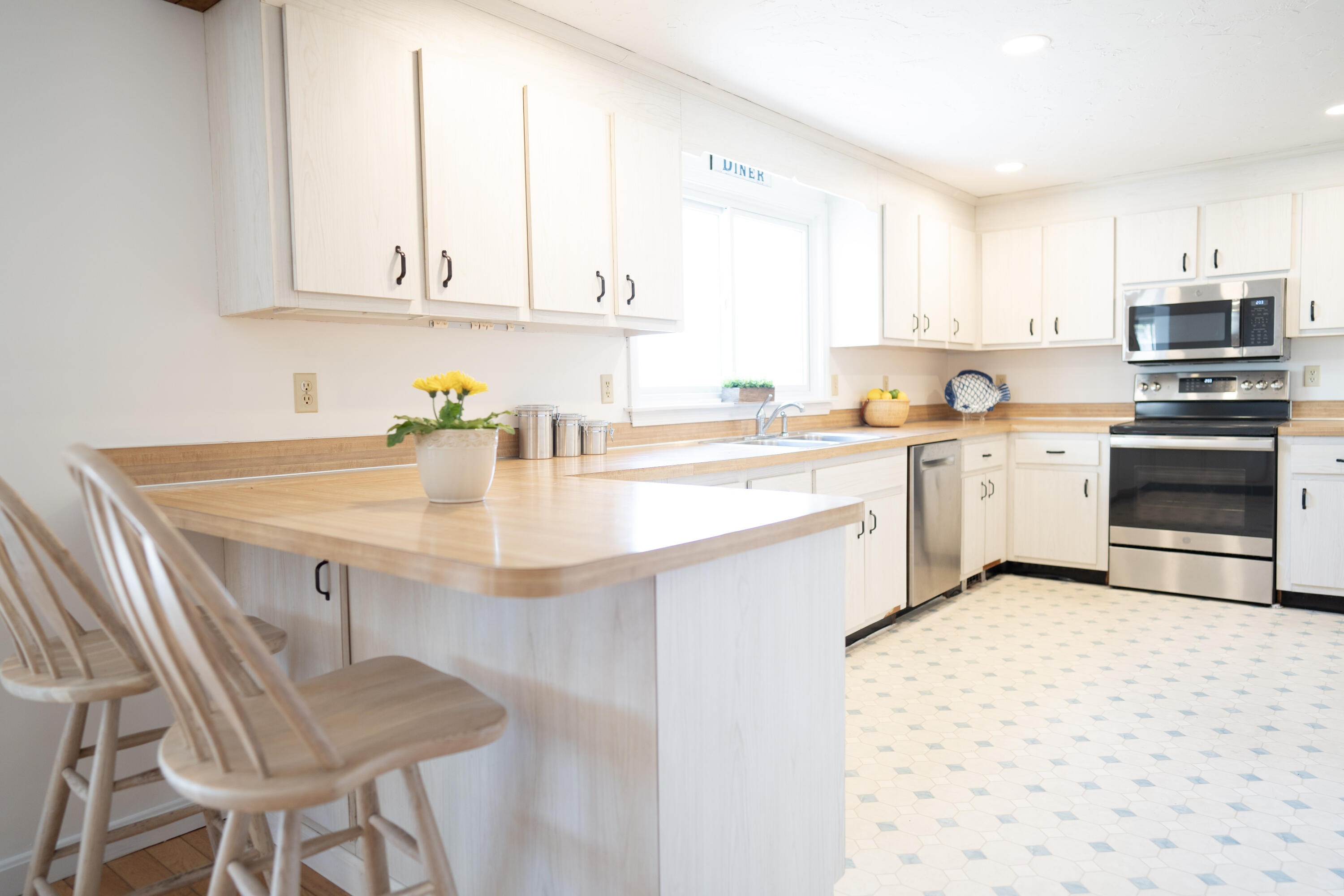 72 Cove Road South Dennis, MA 02660 - Photo 10 of 37 a kitchen with stainless steel appliances granite countertop a sink dishwasher stove and white cabinets with wooden floor