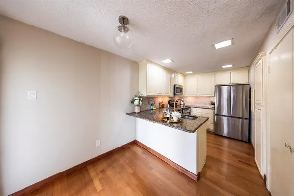 a kitchen with granite countertop a sink stainless steel appliances and cabinets