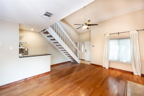 a view of a hallway with wooden floor and staircase