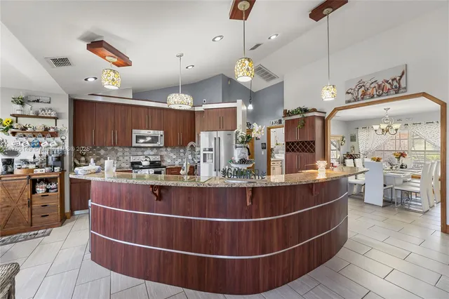 a kitchen with stainless steel appliances granite countertop a refrigerator stove and sink