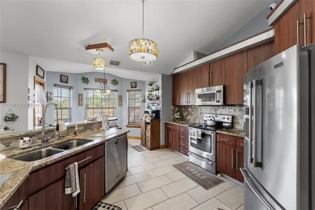 a living room with furniture a chandelier and a dining table