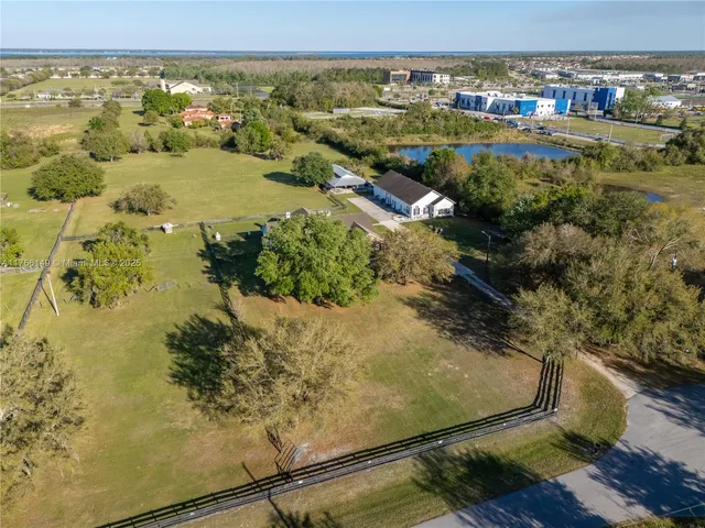 an aerial view of a house with swimming pool and lake view
