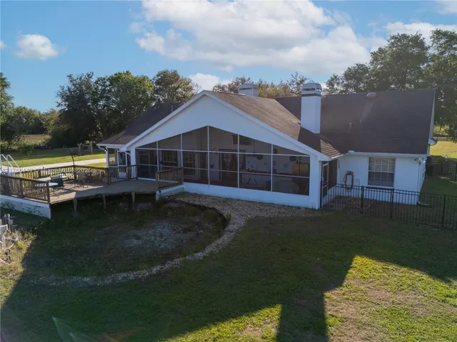 a view of a house with a big yard and large trees