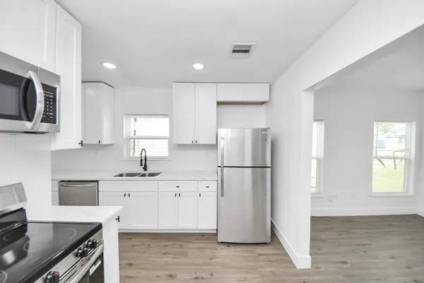 a kitchen with stainless steel appliances a refrigerator stove microwave and sink