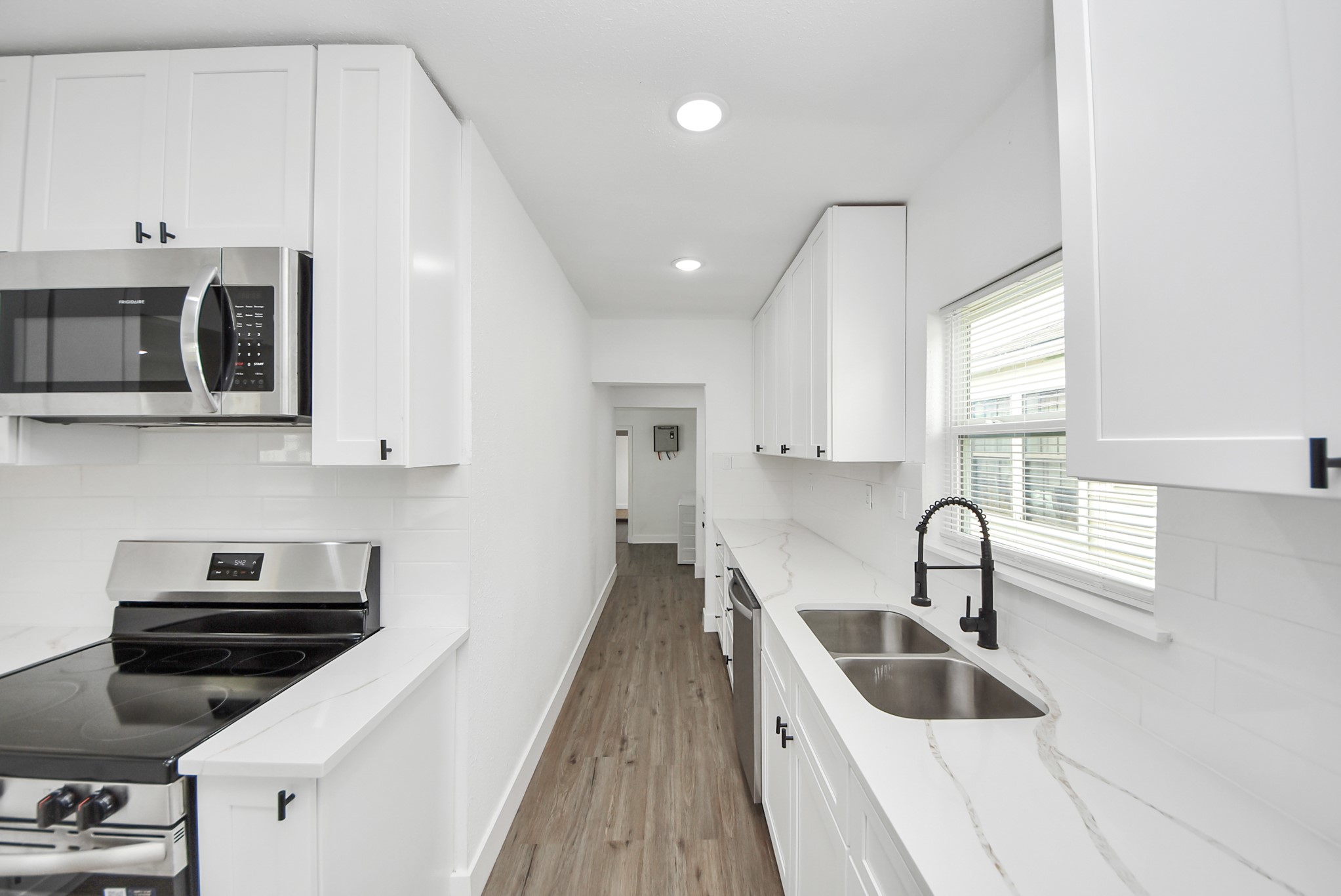 1203 West 6th Street Freeport, TX 77541 - Photo 22 of 50 a kitchen with stainless steel appliances a stove a sink a microwave and cabinets