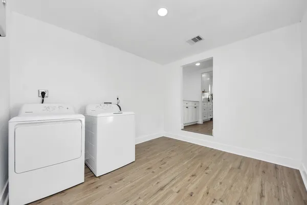 a view of storage and utility room with wooden floor and windows