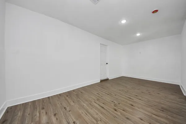 a view of an empty room with wooden floor