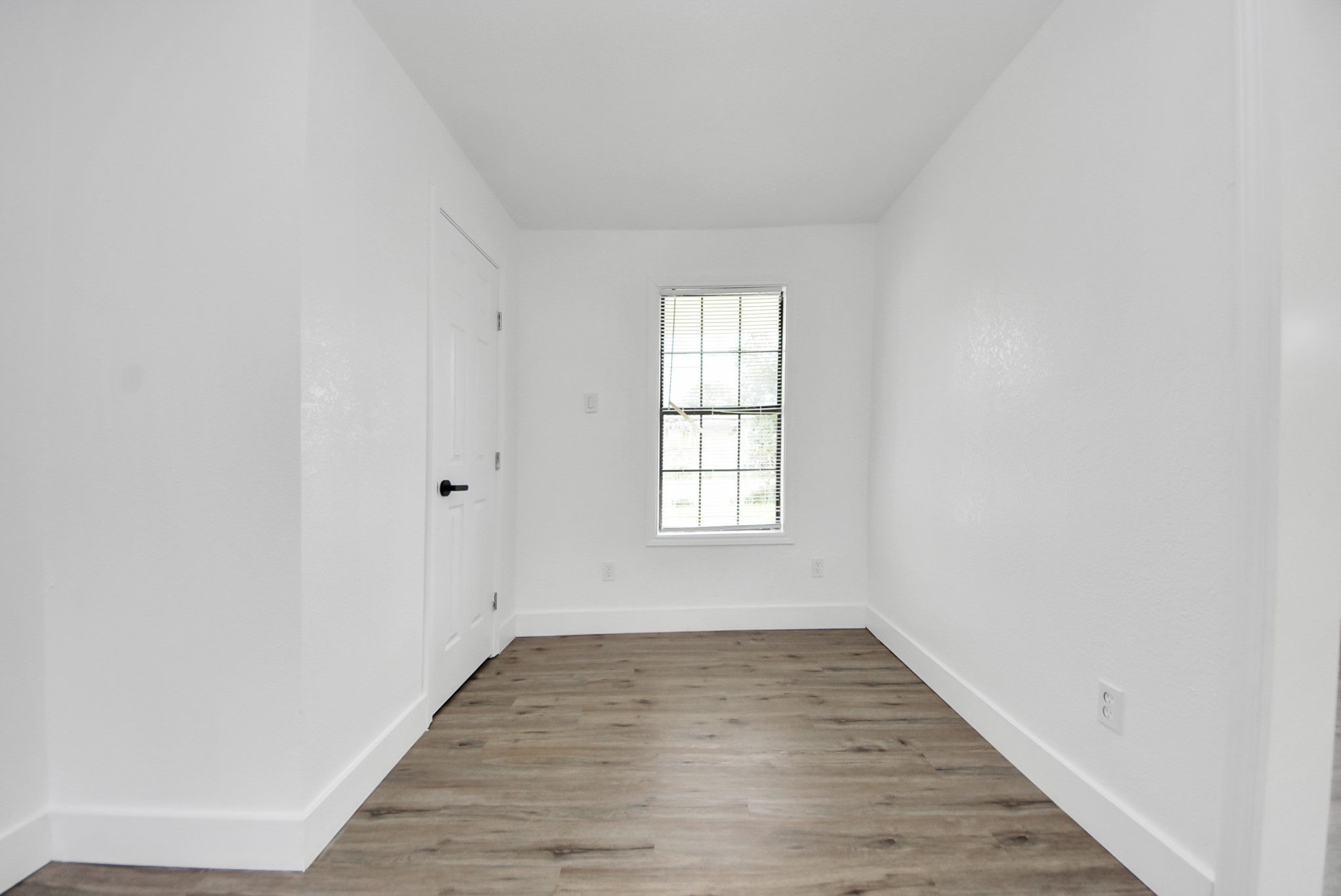 1203 West 6th Street Freeport, TX 77541 - Photo 30 of 50 an empty room with wooden floor and windows