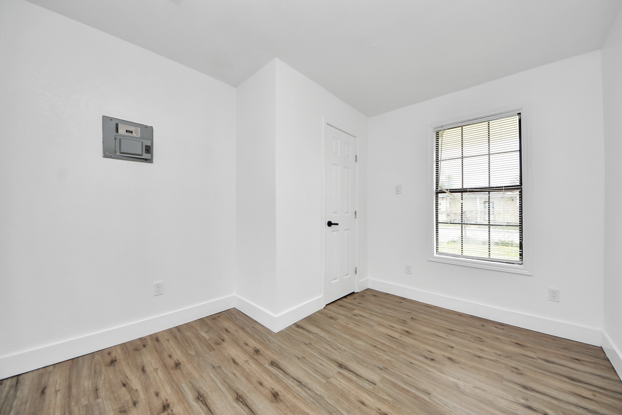 1203 West 6th Street Freeport, TX 77541 - Photo 31 of 50 an empty room with wooden floor and windows