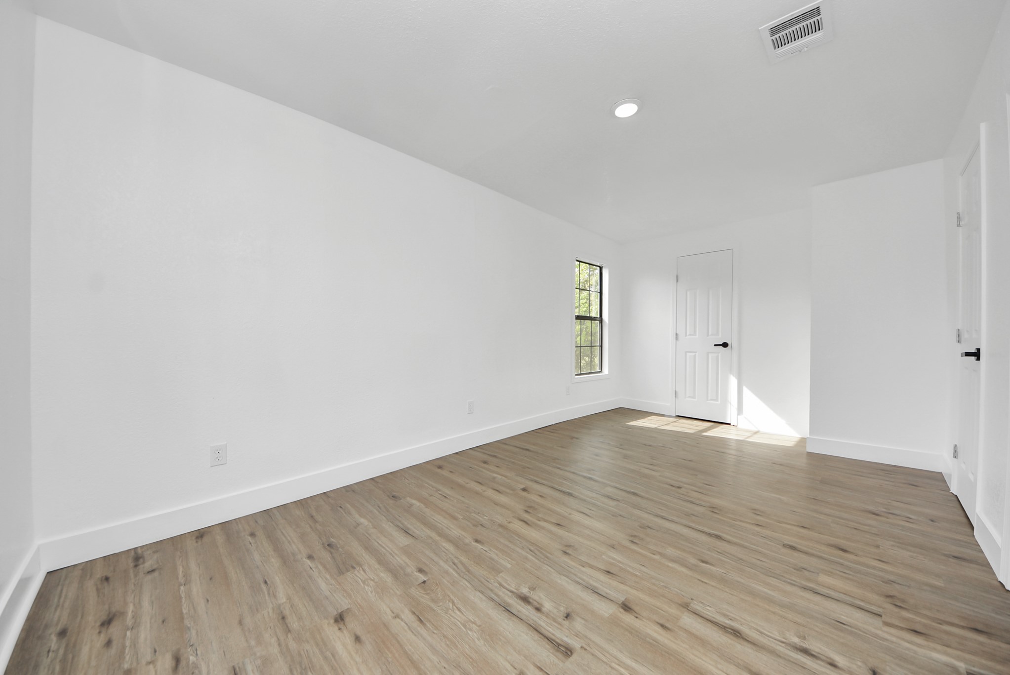 1203 West 6th Street Freeport, TX 77541 - Photo 32 of 50 an empty room with wooden floor and windows
