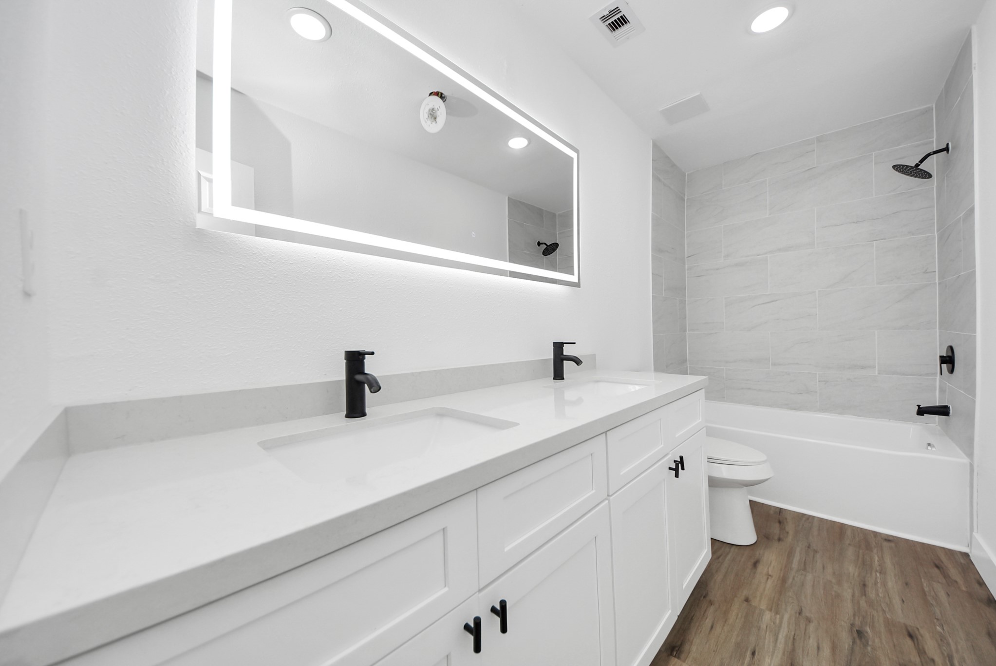 1203 West 6th Street Freeport, TX 77541 - Photo 40 of 50 a bathroom with a double vanity sink a toilet and a bathtub